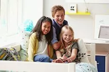 3 Kinder lachend im Flexa Classic Bett